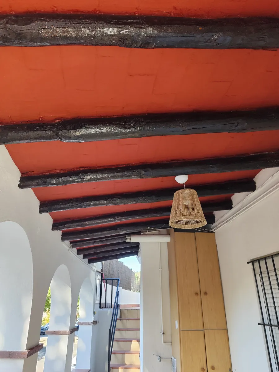 Obra rehabilitación de casa en Sant Boi y porche con arcos detalle techo y muebles bigas madera después de reformar Baix Llobregat. Rehabilitación integral de viviendas
