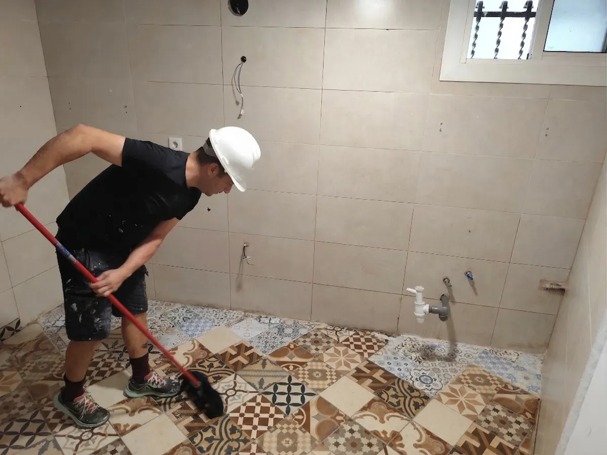 Reformista Limpiendo Suelo Antes De Colocación De Muebles De La Cocina. Rehabilitación integral de viviendas